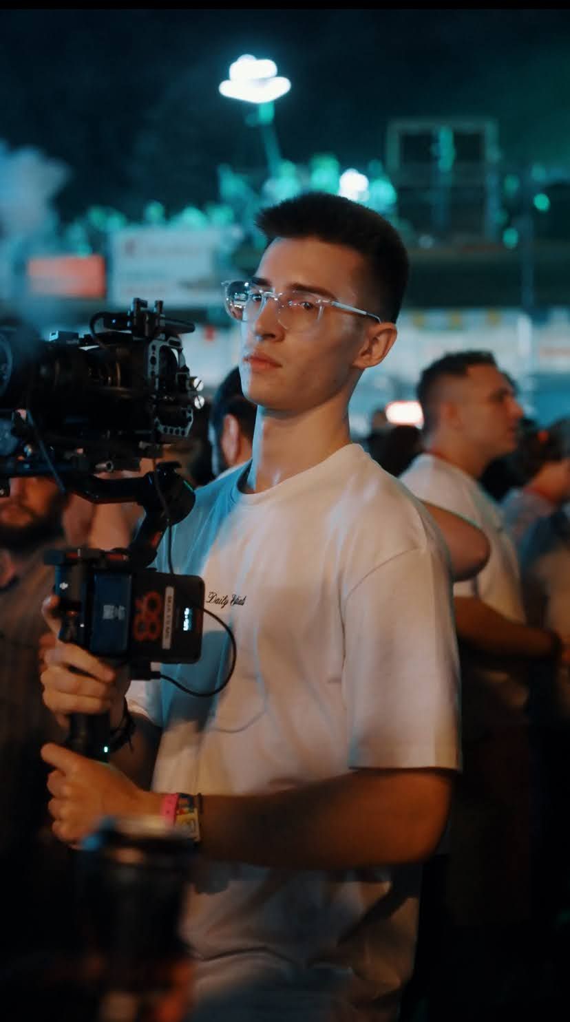 Matei filming with a gimbal at a festival at night